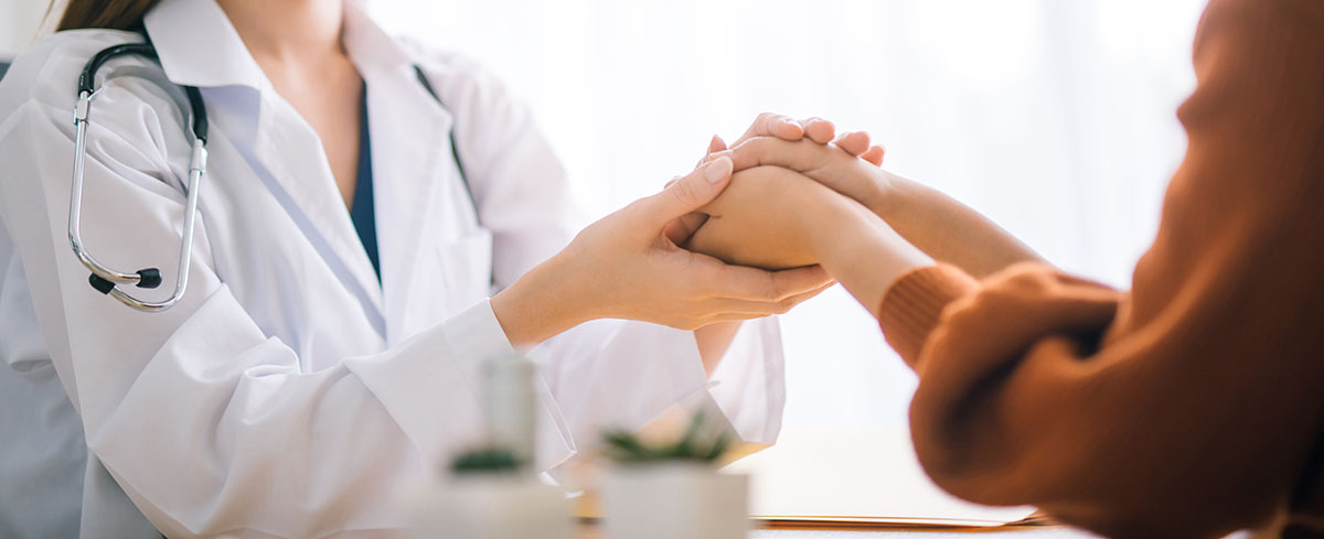 Doctor holding hands of patient